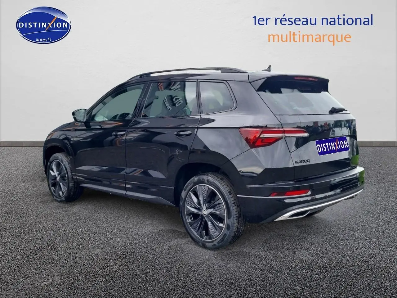 SUV SKODA KAROQ noir vu en 3/4 arrière droit avec jantes alu et barres de toit visibles