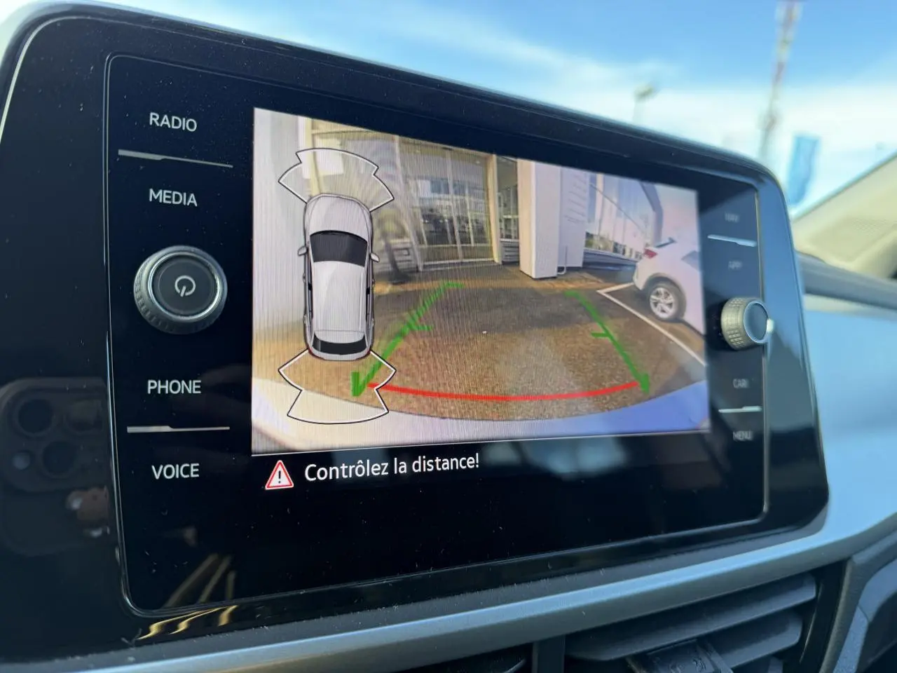 Écran tactile intérieur du Volkswagen T-Roc gris Pyrite montrant la caméra de recul avec guidage de trajectoire.