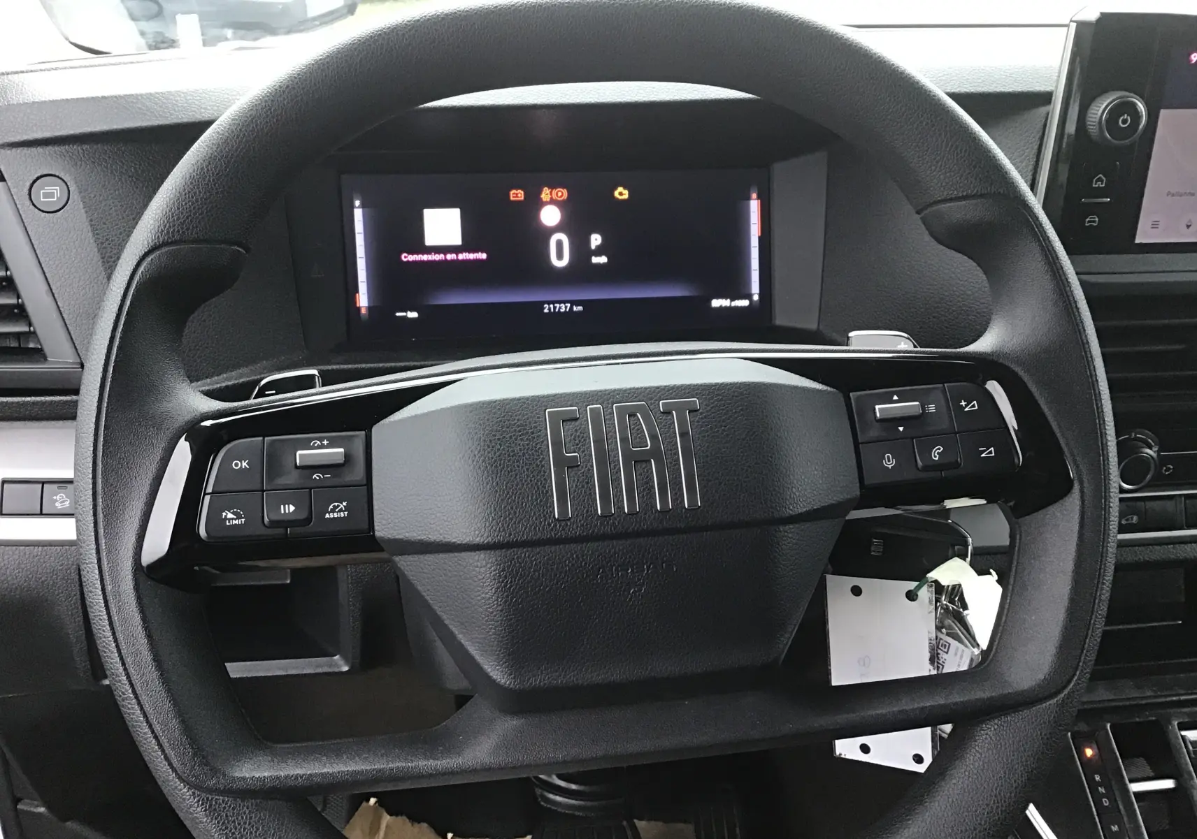 Vue rapprochée du volant noir du Fiat Scudo Fourgon 2024 avec tableau de bord numérique et commandes intégrées.