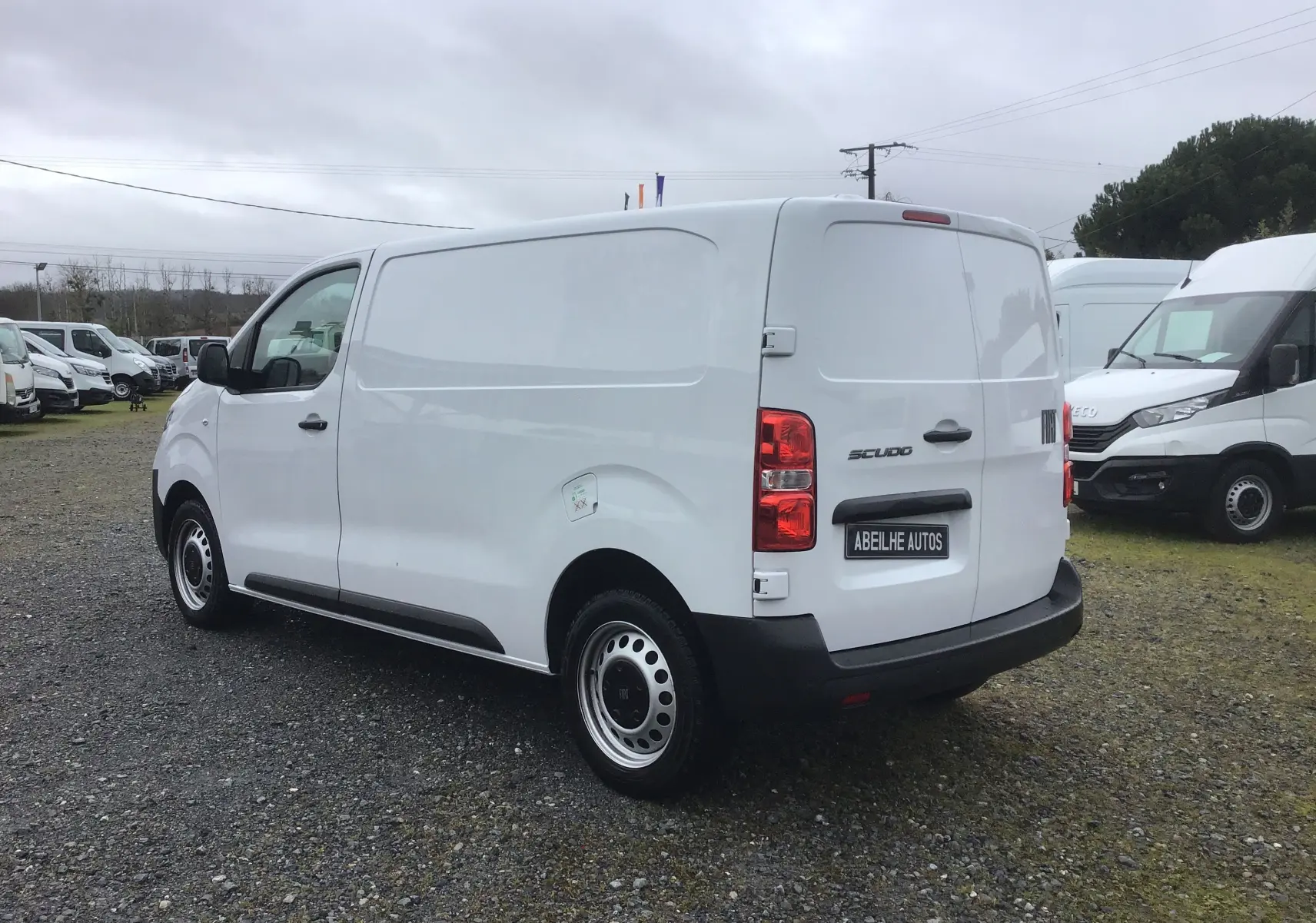 Vue 3/4 arrière droite d'un FIAT Scudo Fourgon blanc 2024 avec plaque de protection noire et jantes acier.