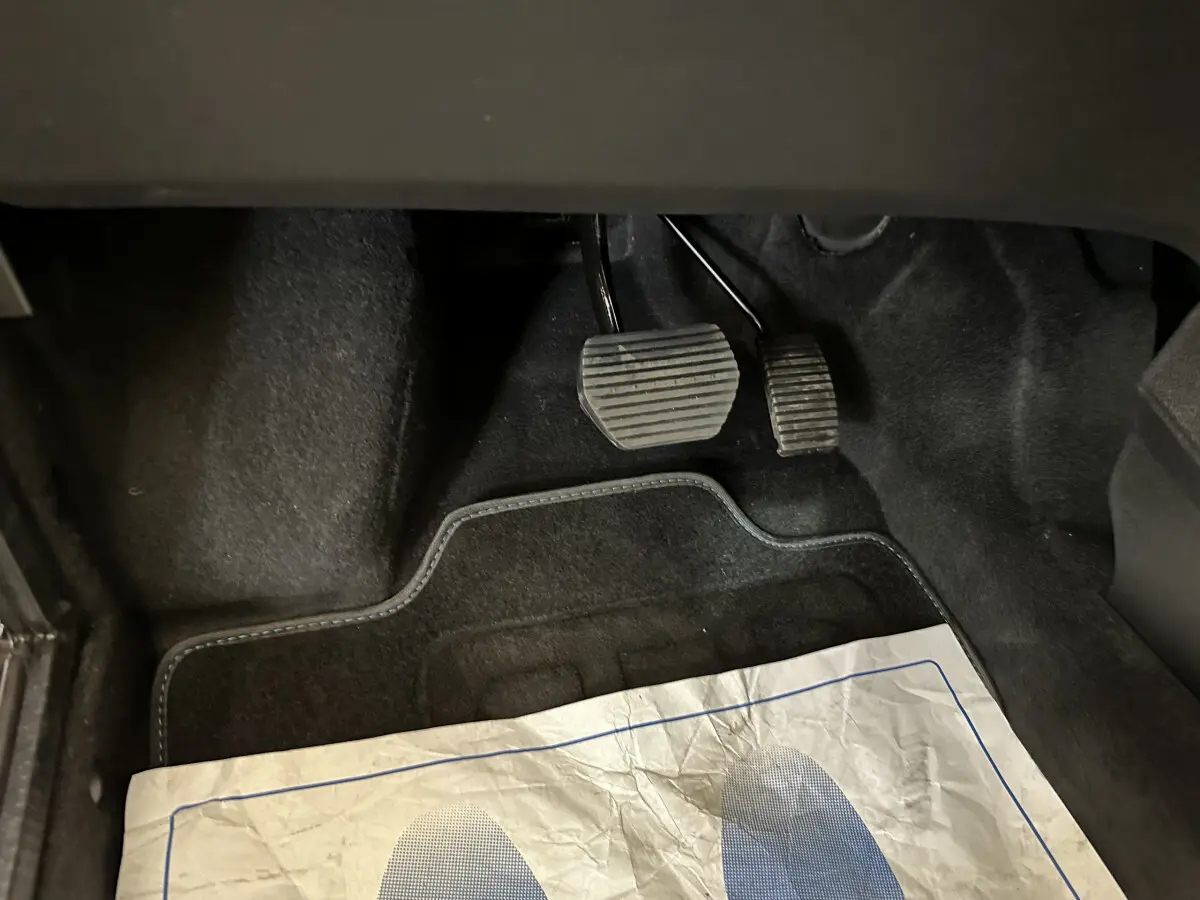 Vue rapprochée des pédales d’embrayage et de frein dans l’habitacle d’une Aixam Ambition 2026.