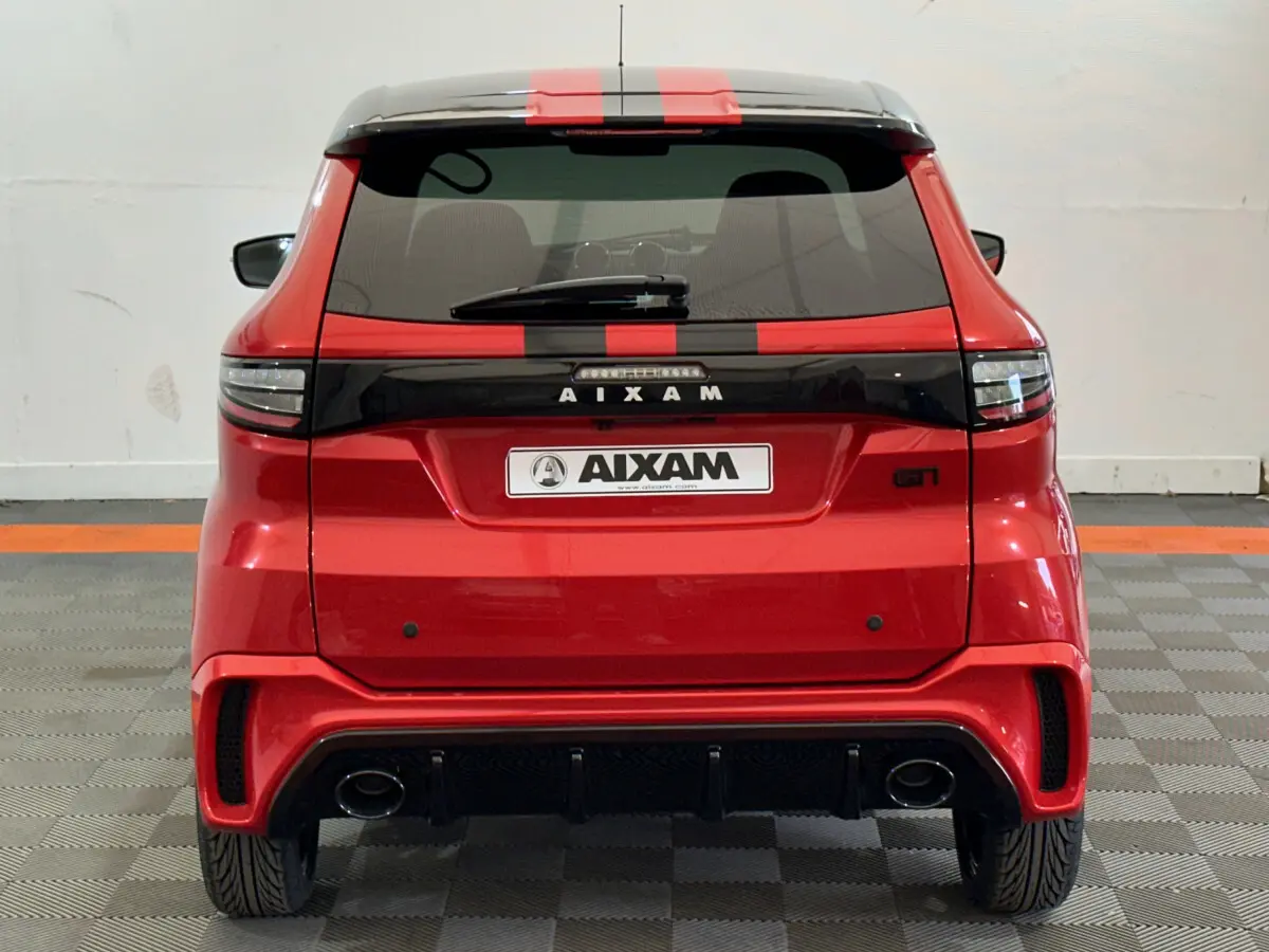 Vue arrière d'une AIXAM Ambition rouge 2026 avec bandes noires et double sortie d'échappement visible.