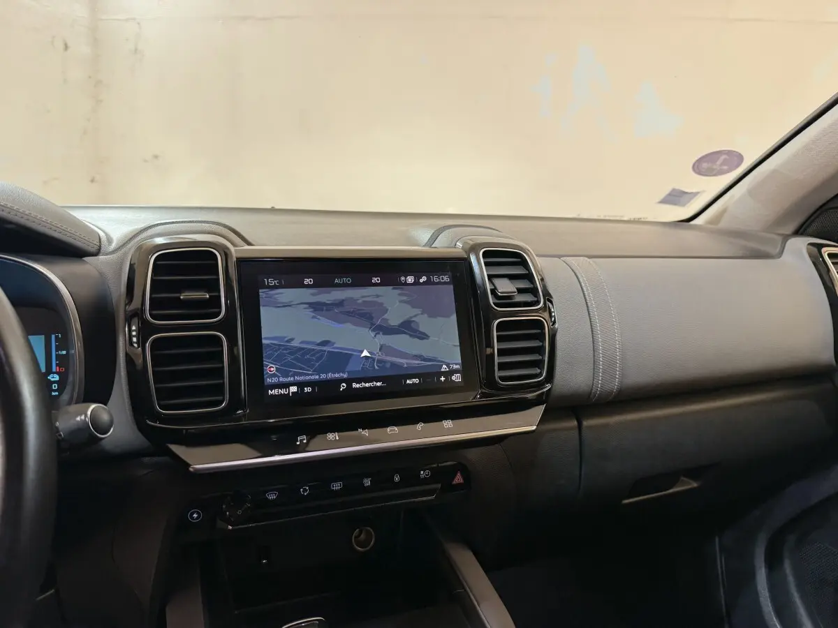 Vue intérieure du tableau de bord du Citroën C5 Aircross Hybrid bleu, avec écran tactile central affichant la navigation.