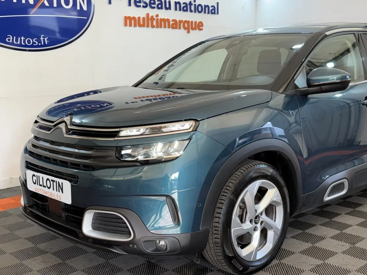 Vue 3/4 avant droit d'un Citroën C5 Aircross Hybrid bleu avec phares LED et jantes alliage distinctives.
