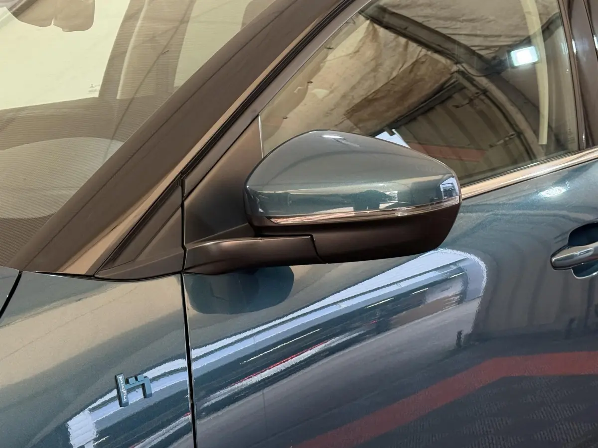 Détail du rétroviseur droit bleu métallisé du Citroën C5 Aircross Hybrid 225 ë-EAT8 Business, avec logo Hybrid visible sur la portière.