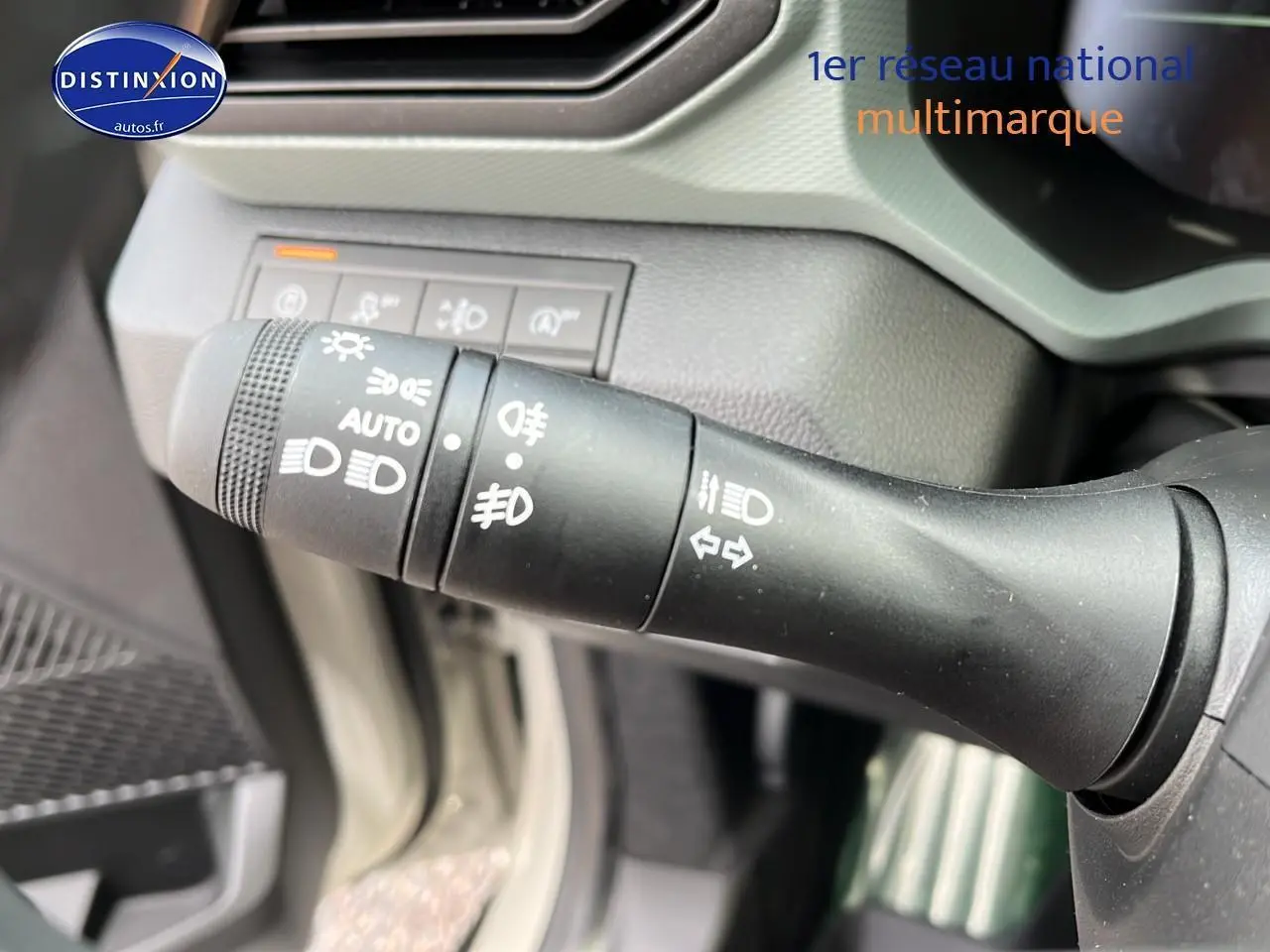 Gros plan sur la commande des phares et clignotants du Dacia Duster 2025, intérieur noir et gris.