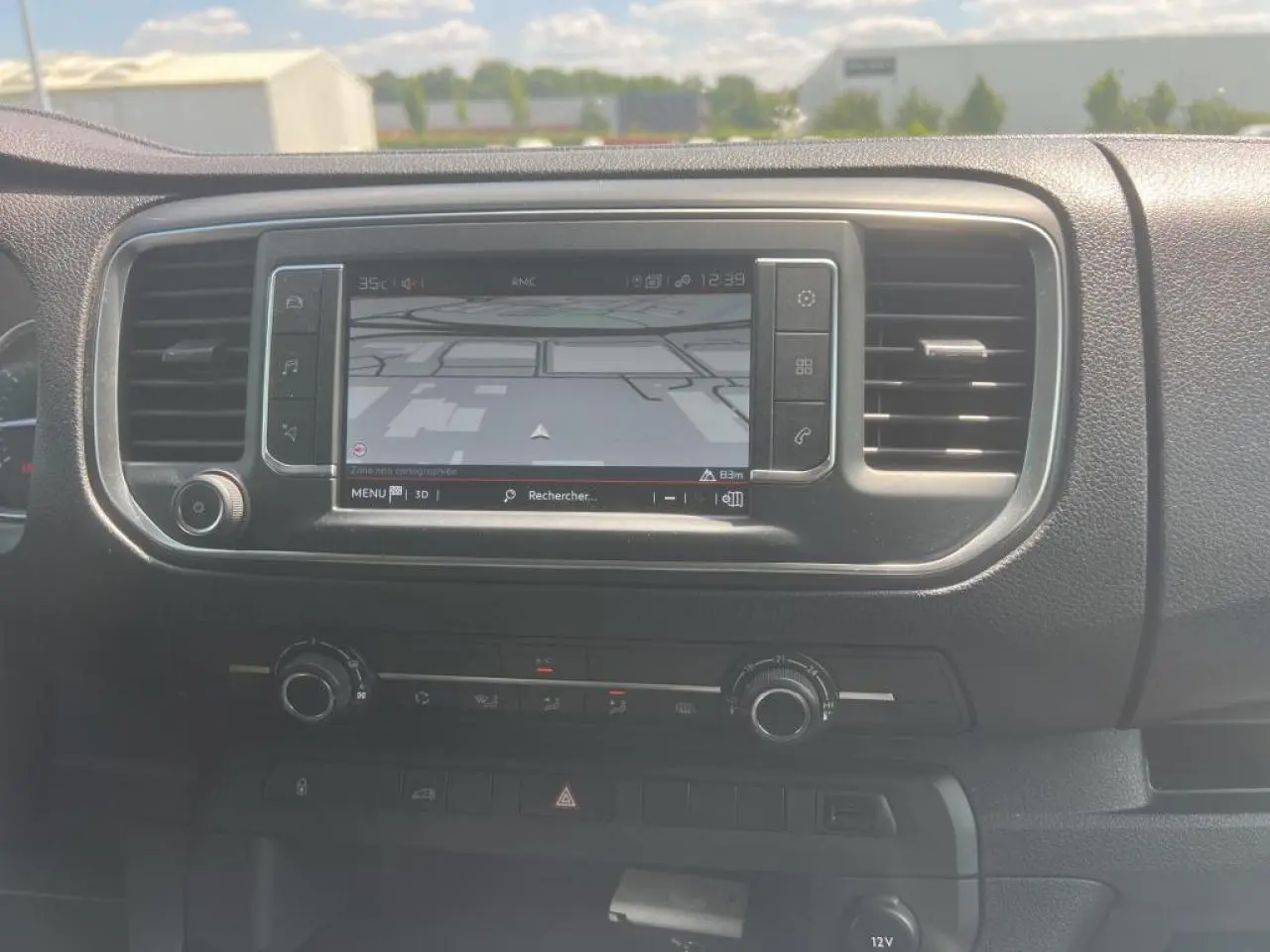 Tableau de bord du Citroën Jumpy XL blanc 2023 montrant l'écran tactile de navigation 3D et commandes de climatisation.