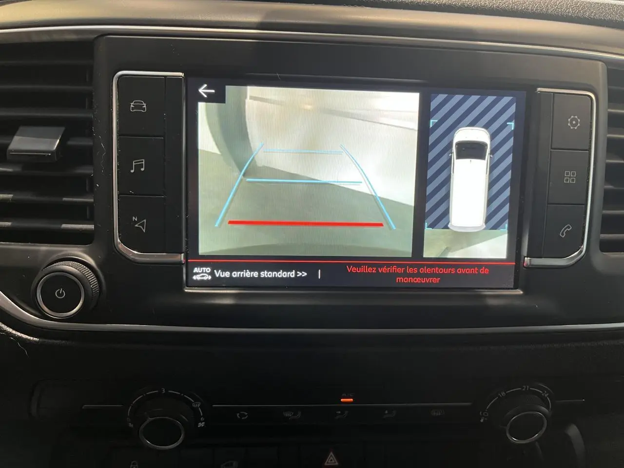 Écran tactile du tableau de bord du Citroën Jumpy blanc montrant la caméra de recul et l'aide au stationnement.