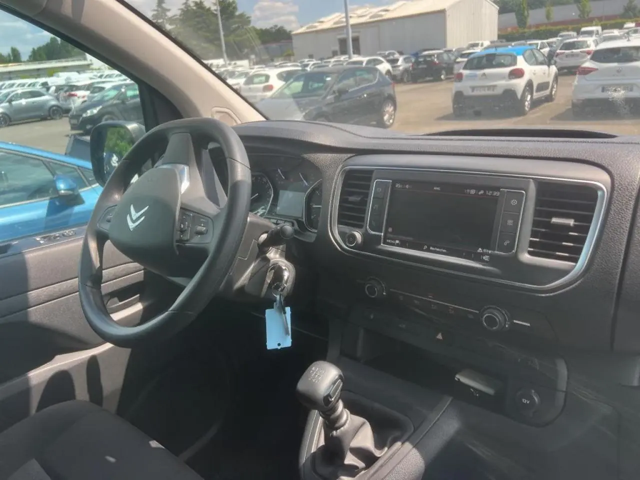 Vue intérieure côté conducteur du Citroën Jumpy blanc 2023, montrant volant, tableau de bord et écran tactile central.