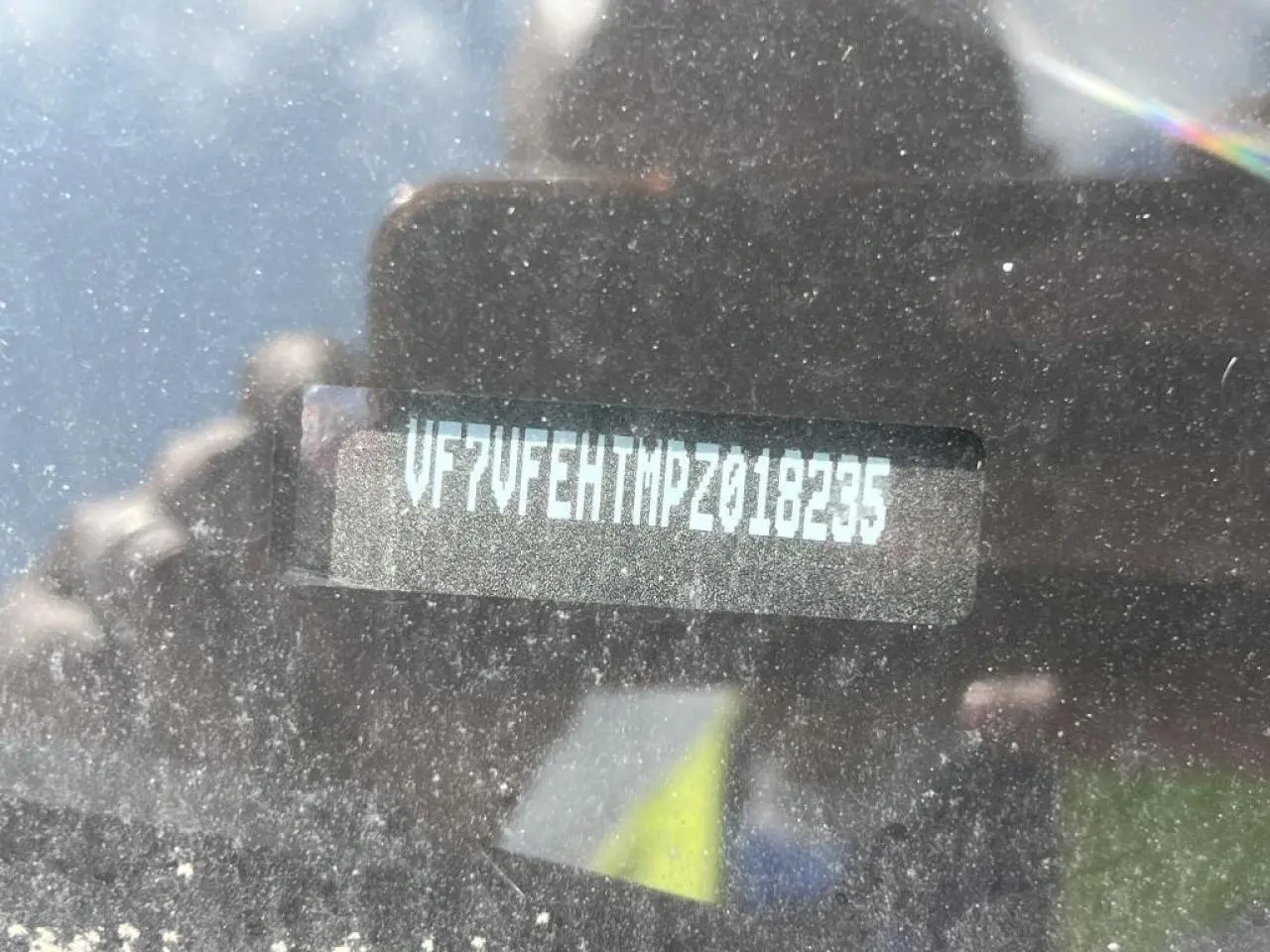 Gros plan sur le numéro VIN visible à travers le pare-brise d'un Citroën Jumpy blanc 2023