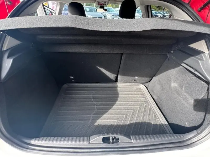 Coffre ouvert vu de l'arrière d'une Citroën C3 2017 blanc Banquise avec tapis de sol noir et intérieur sombre.