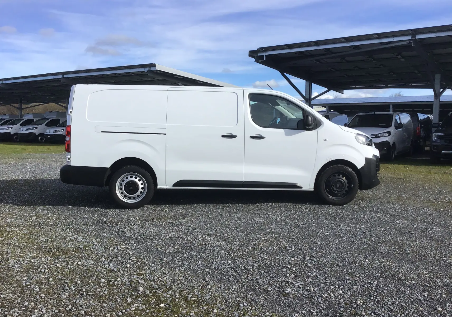 Vue de profil côté gauche d’un FIAT Scudo Fourgon blanc 2024 avec garde au sol réhaussée et plaque de protection tôlée.