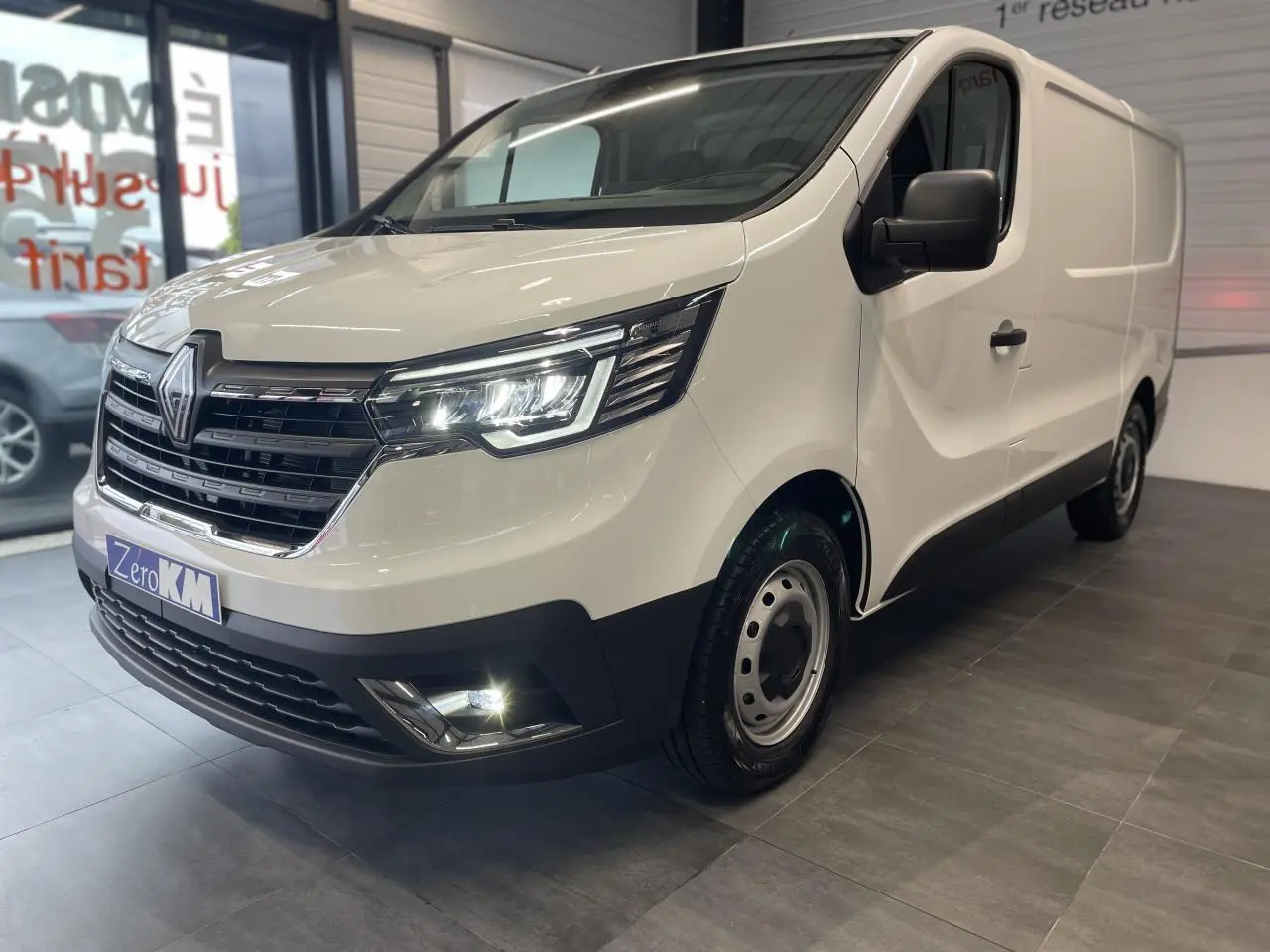 Vue 3/4 avant droit du Renault Trafic Fourgon blanc Glacier avec projecteurs Full LED et jantes tôles 16 pouces.
