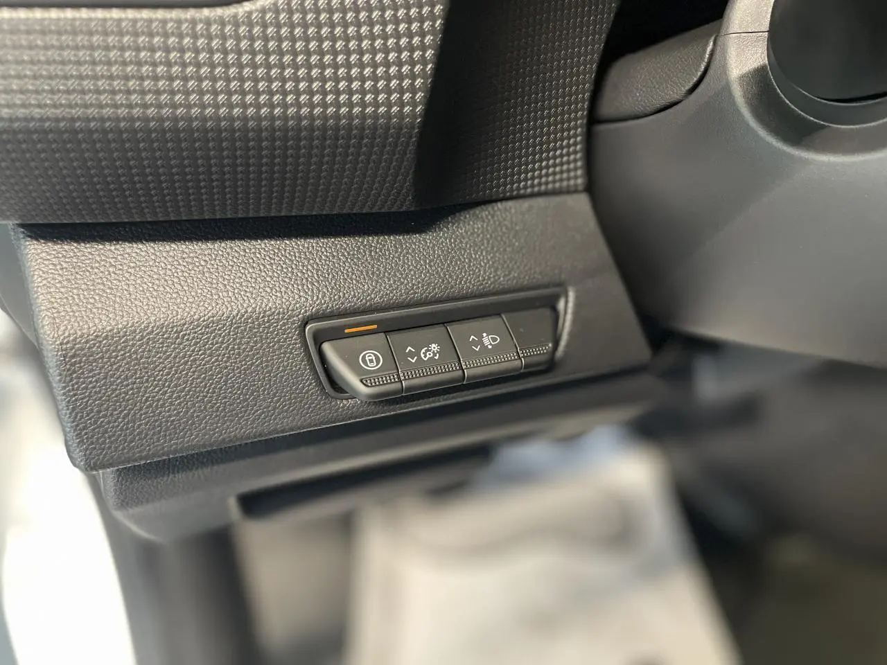 Gros plan sur les commandes de réglage d'éclairage et verrouillage dans l'habitacle du Renault Trafic Fourgon blanc.