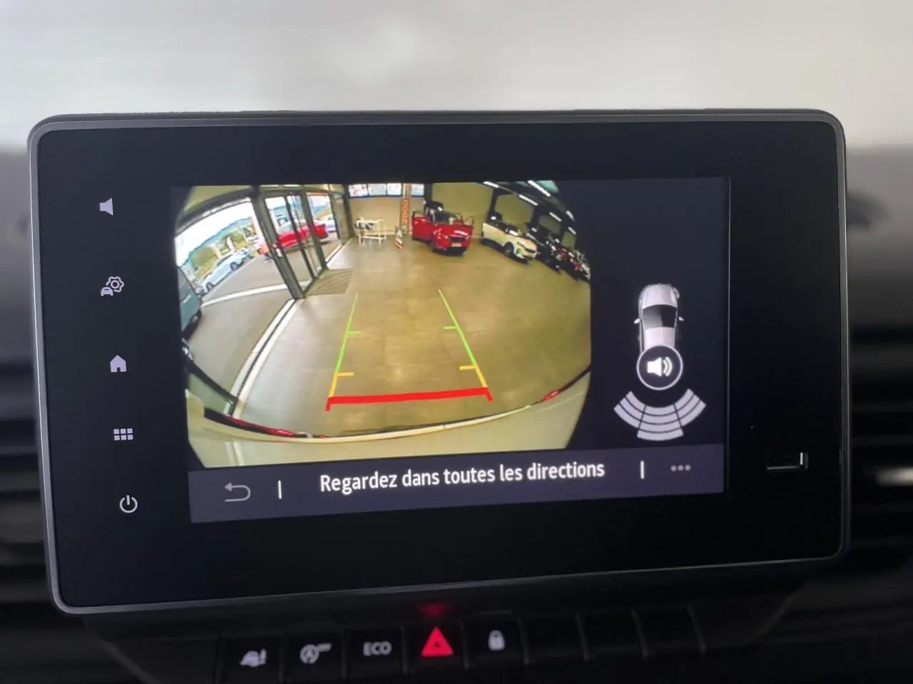 Écran multimédia montrant la caméra de recul du Renault Trafic Fourgon blanc avec lignes de guidage colorées.