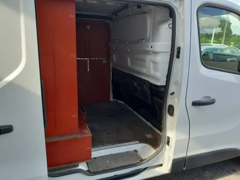 Vue intérieure côté droit du Renault Trafic Fourgon blanc glacier 2019 avec habillage latéral bois visible dans l'espace de chargement.