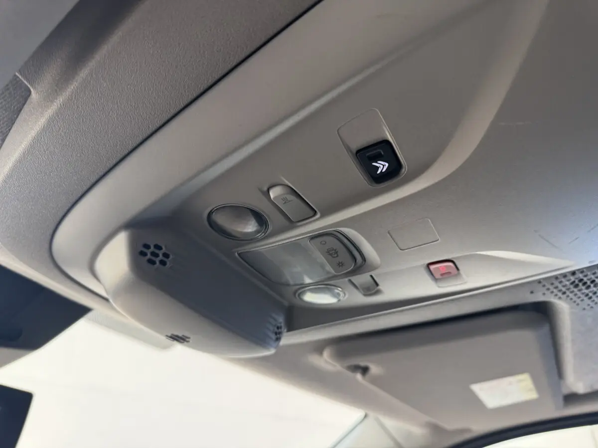 Plafonnier intérieur gris clair du Citroën Berlingo 2020 avec commandes d’éclairage et bouton d’alerte rouge visible.