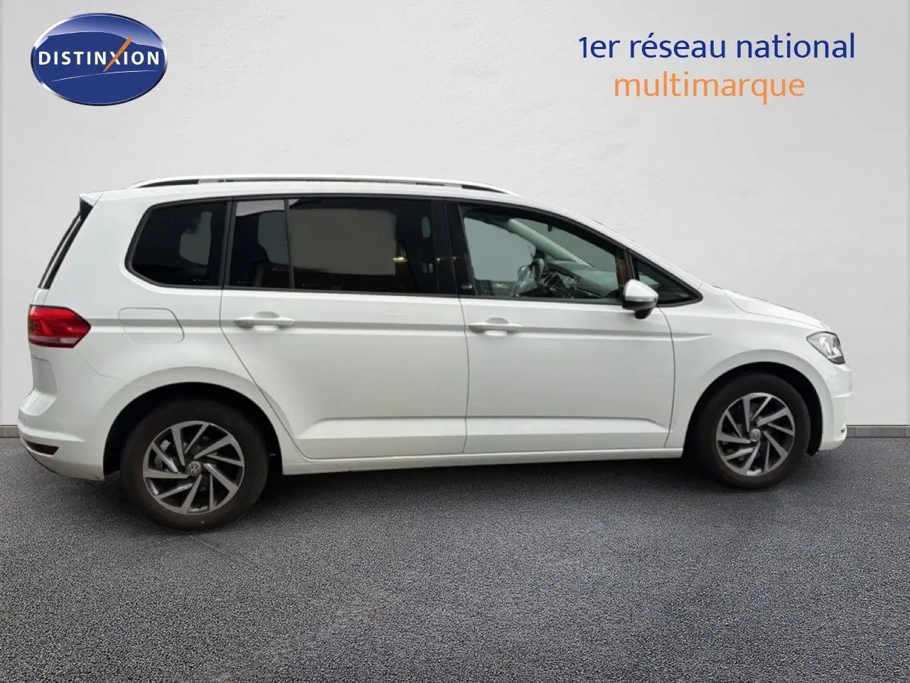 Profil droit d'un Volkswagen Touran blanc 2018 avec jantes alliage bicolores et vitres teintées.