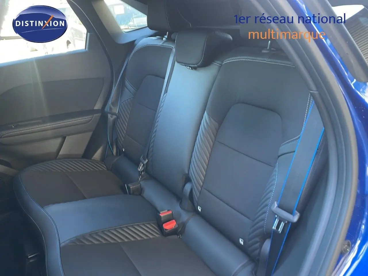 Vue intérieure sur la banquette arrière en cuir noir avec surpiqûres bleues du Renault Symbioz bleu Iron Metal.