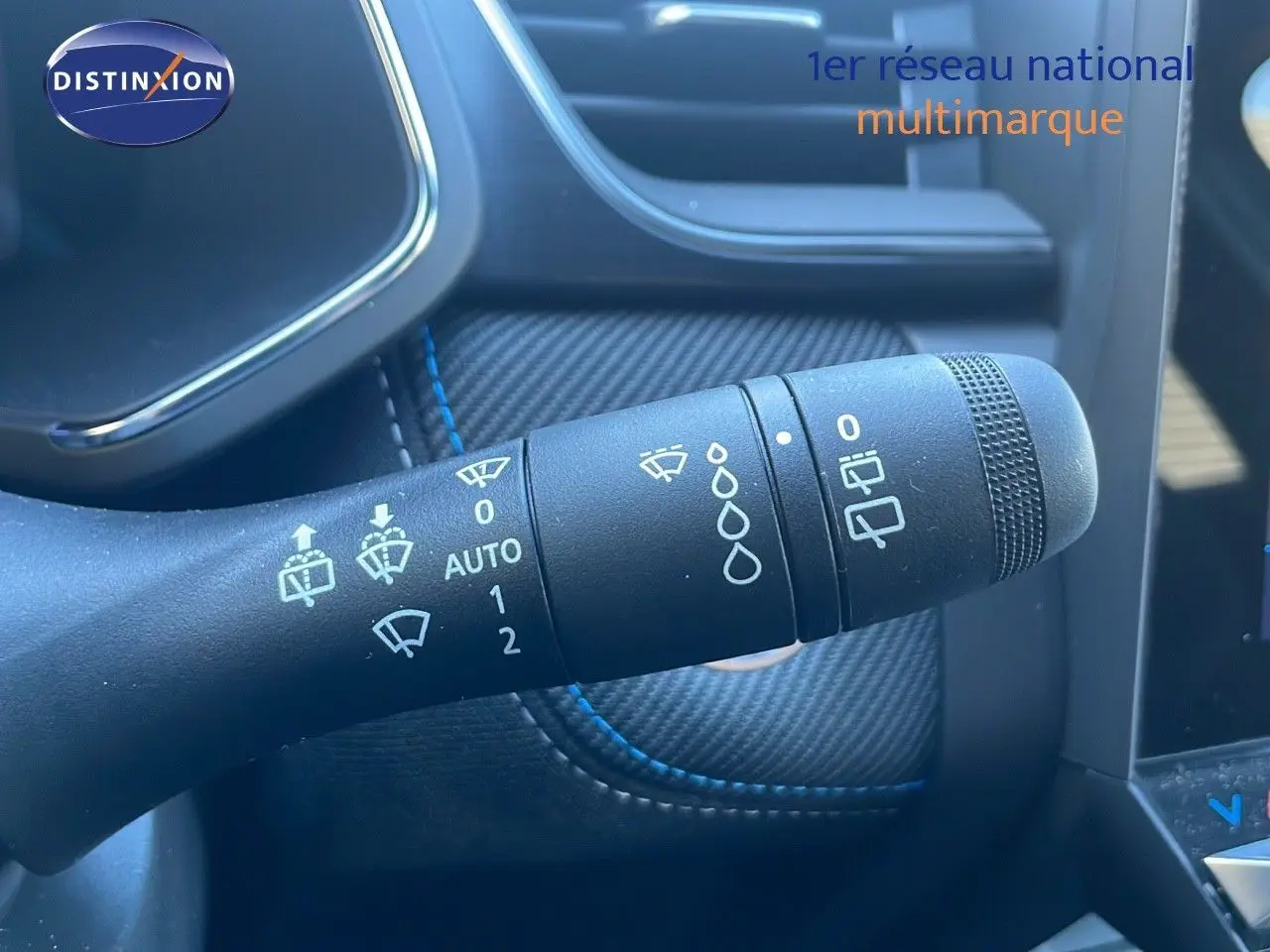 Gros plan sur la commande d'essuie-glace du Renault Symbioz bleu iron metal, soulignant les réglages automatiques et manuels.