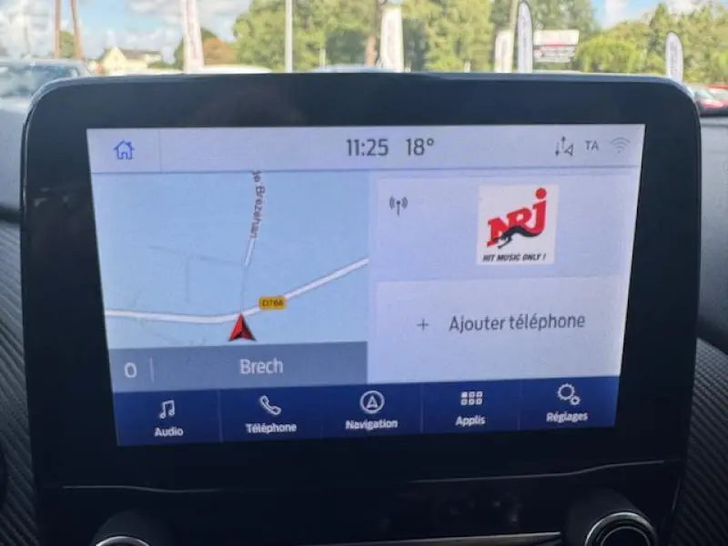 Écran tactile du système de navigation du Ford Puma 2023 affichant une carte et options multimédia en intérieur voiture.