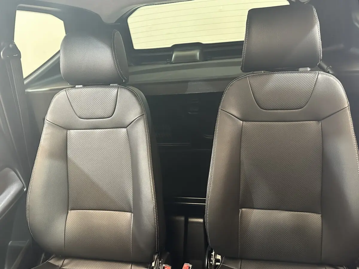 Vue intérieure rapprochée des sièges avant en cuir noir de l'AIXAM AMBITION 0.5 CITY SPORT 2026.