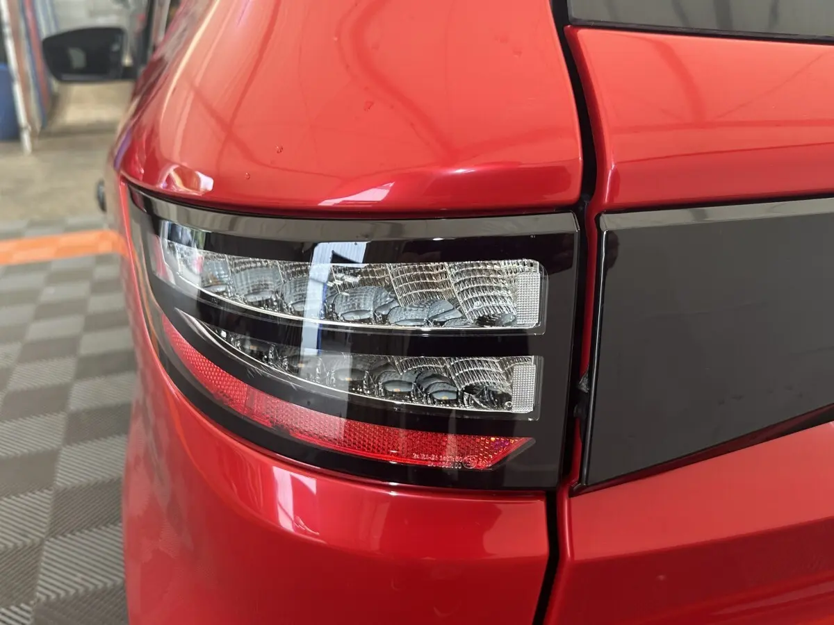 Gros plan sur le feu arrière droit rouge de l'AIXAM AMBITION 0.5 CITY SPORT 2026 avec détails noirs brillants.