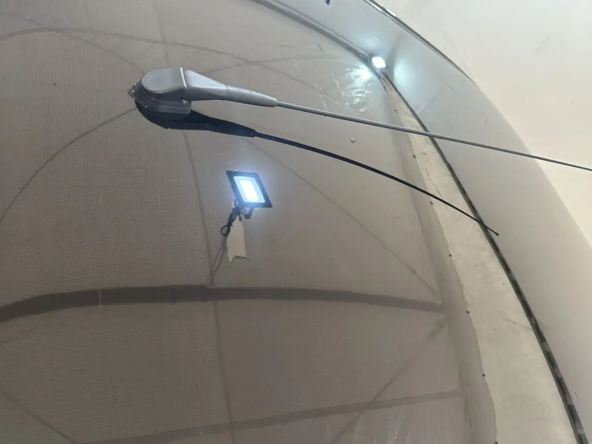 Gros plan sur l'antenne radio noire sur le toit d'une Aixam Ambition rouge, vue en légère plongée.