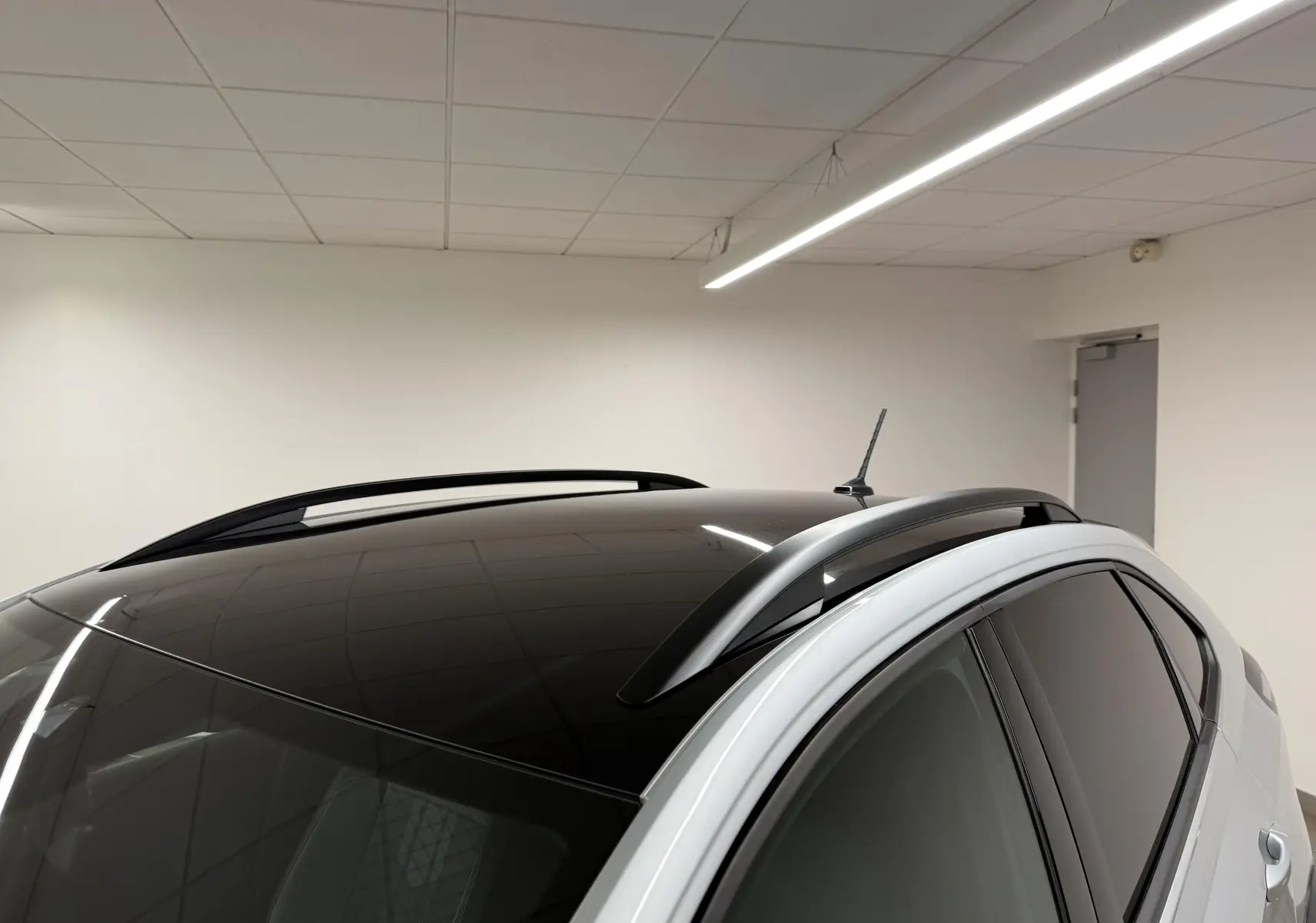 Vue rapprochée du toit noir brillant et des barres de toit argentées du Volkswagen Taigo 1.5 TSI 150 DSG7 R-Line Edition.