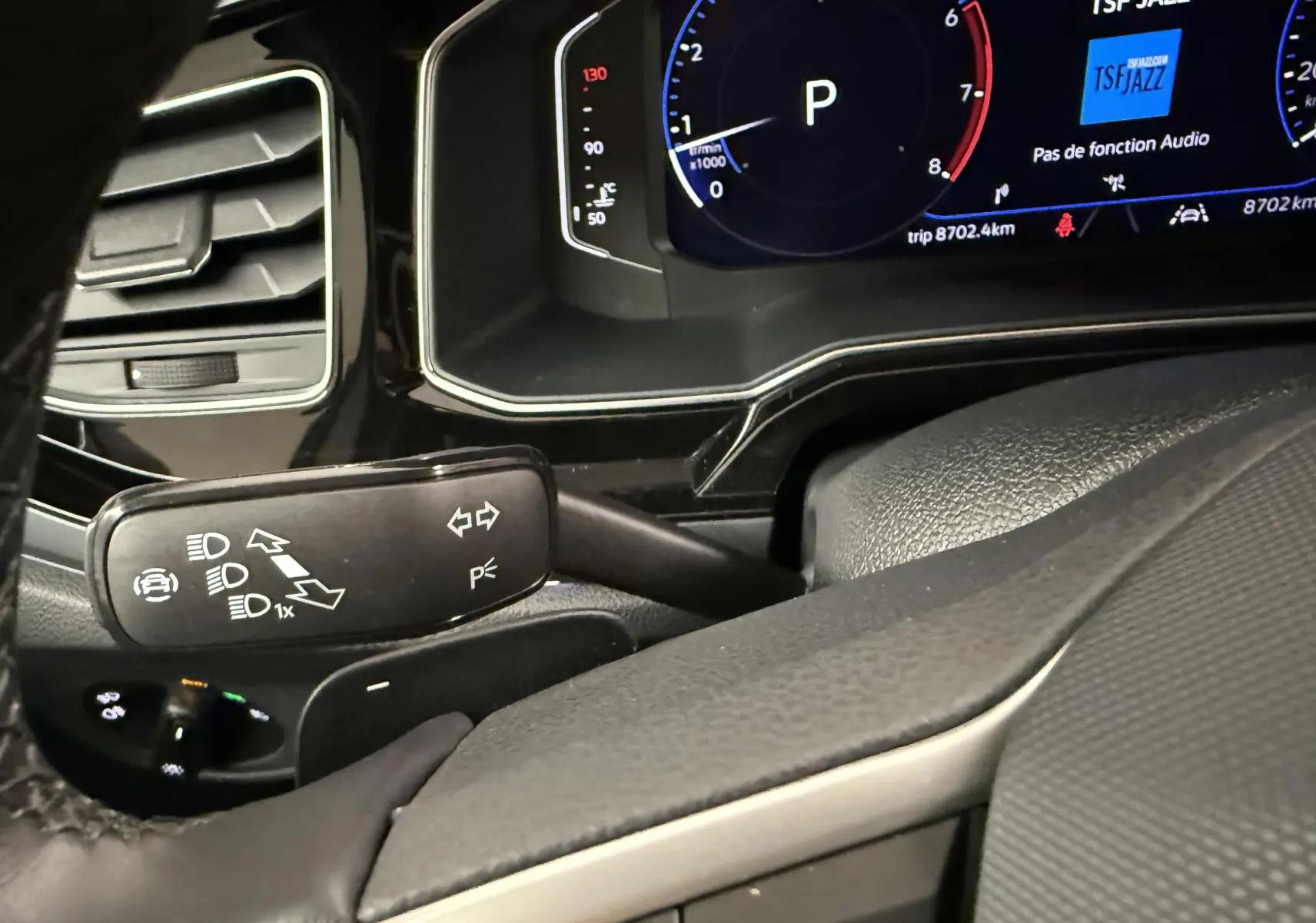 Gros plan sur la commande de clignotants et le tableau de bord numérique du Volkswagen Taigo 1.5 TSI 150 DSG7 R-Line.