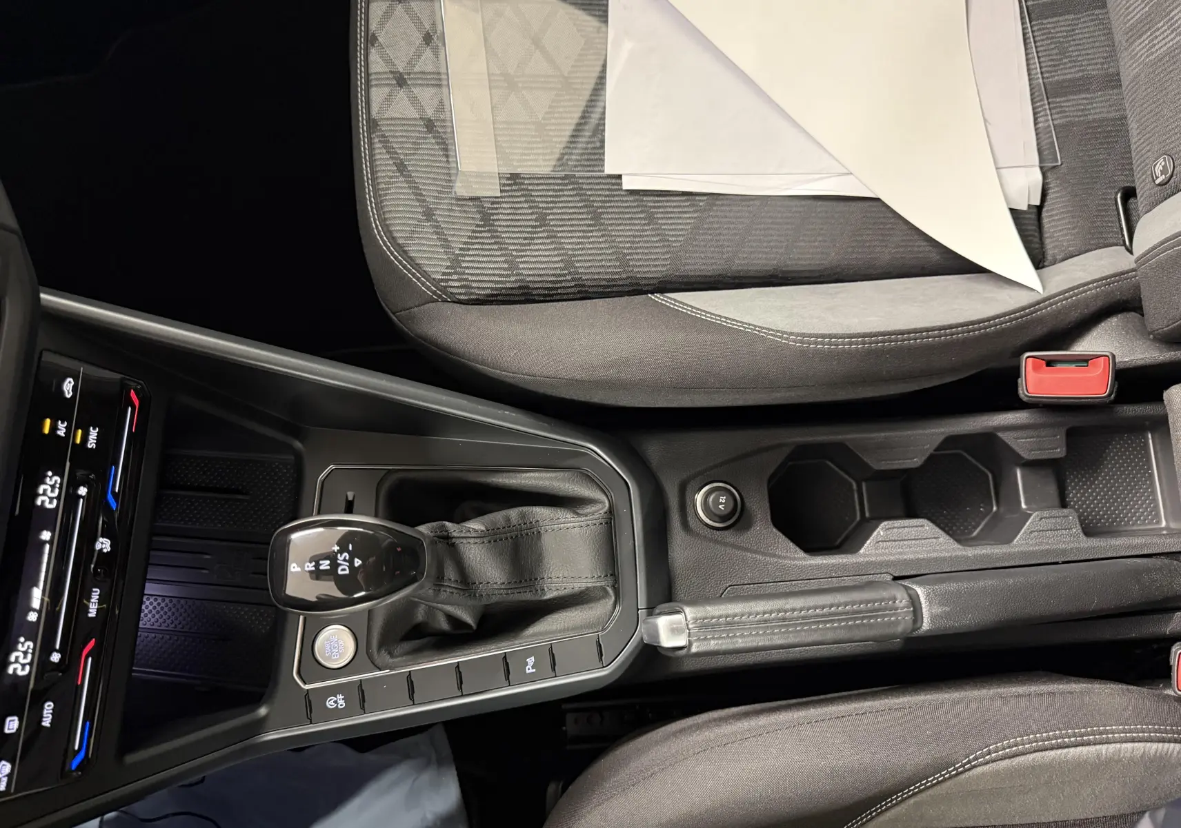 Vue intérieure centrée sur la console centrale du Volkswagen Taigo 1.5 TSI 150 DSG7 R-Line Edition avec levier de vitesse et sièges gris.