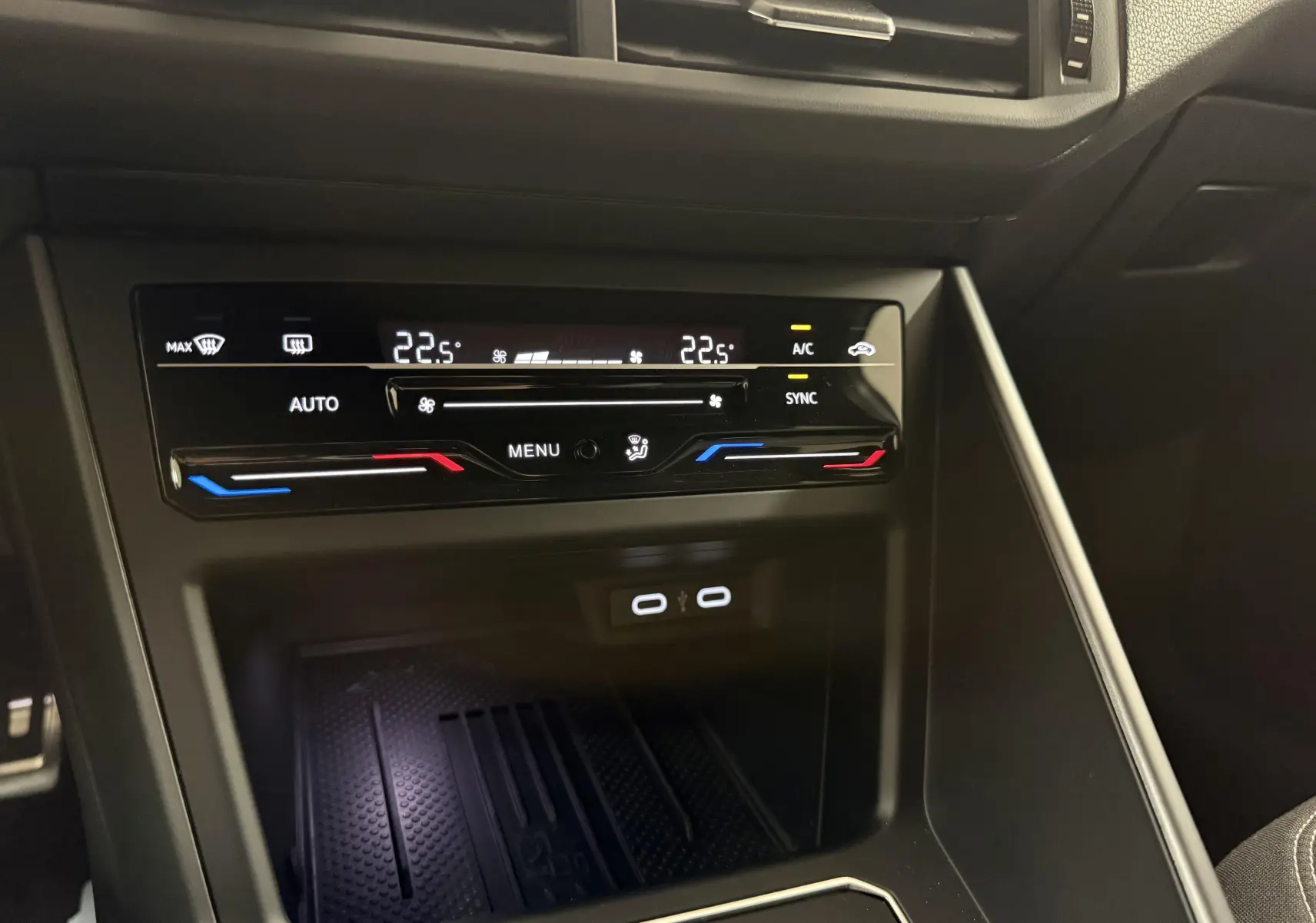Vue rapprochée de la console centrale du Volkswagen Taigo 2025, affichant la climatisation digitale et deux ports USB.