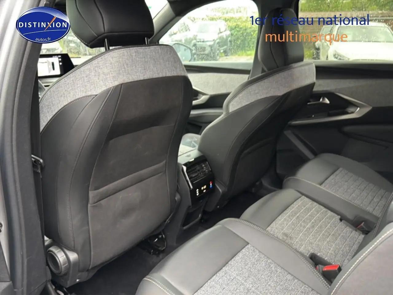 Vue intérieure arrière du Peugeot 5008 Hybrid 145 allure e-dcs6, sièges gris clair et foncé avec console centrale visible.