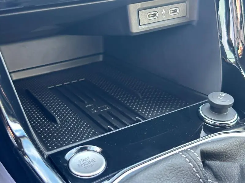 Gros plan sur la console centrale noire du Volkswagen T-Cross argenté 2026, avec bouton Start/Stop et prises USB visibles.