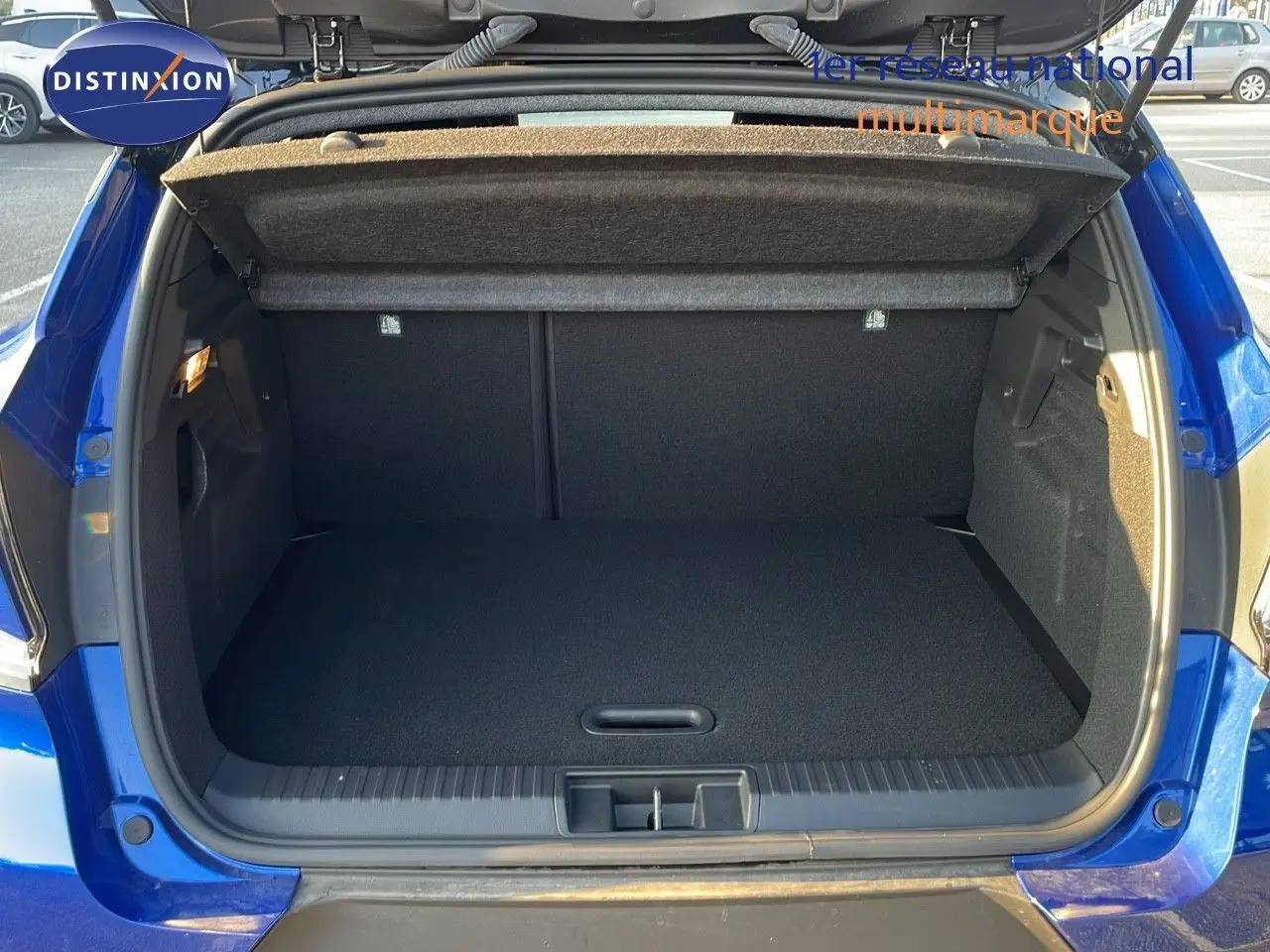 Coffre ouvert vu de l'arrière d'un Renault Captur E-Tech hybride bleu Iron Metal avec toit noir, 2025.