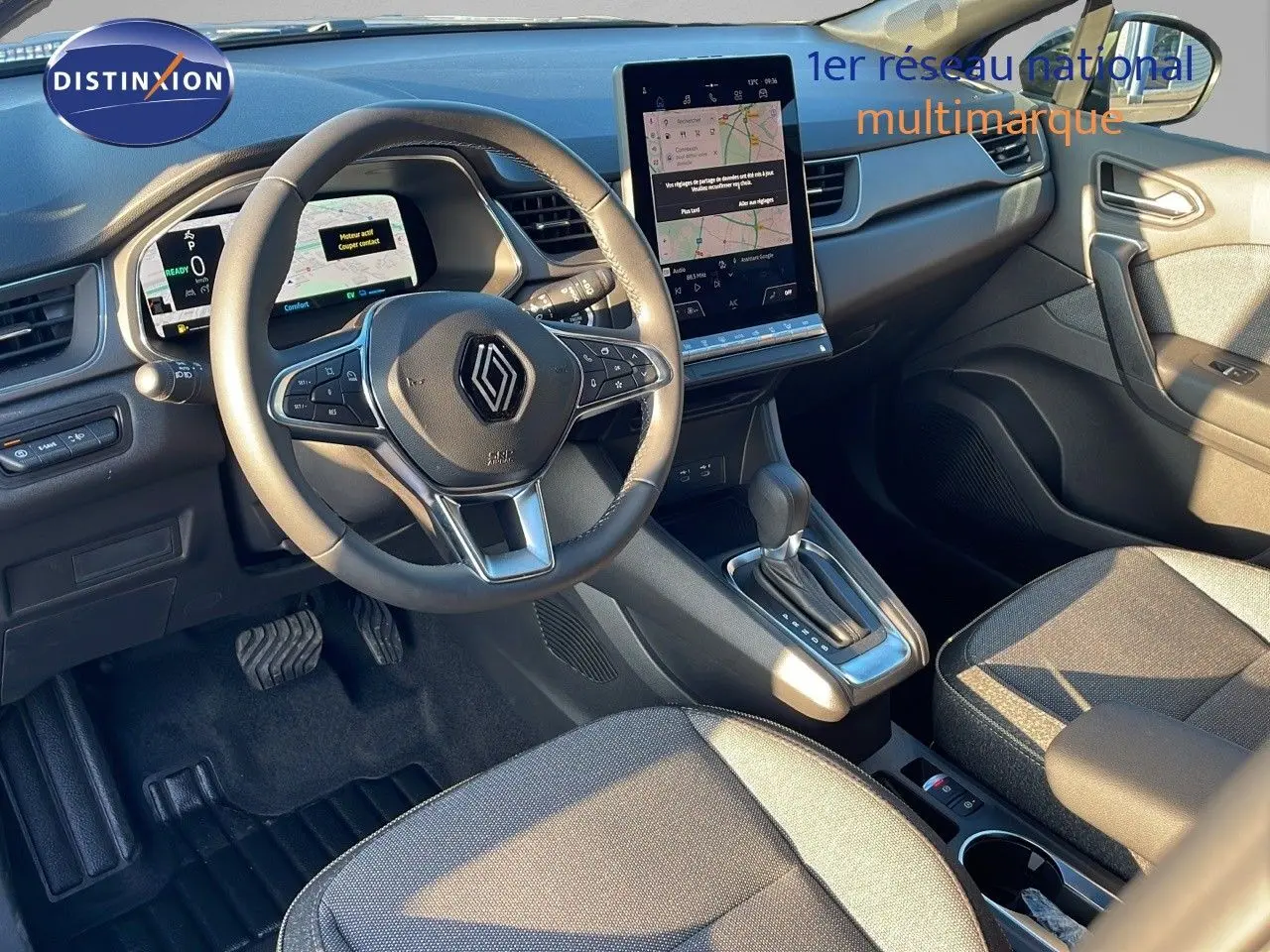 Vue intérieure côté conducteur du Renault Captur E-Tech hybride 2025, tableau de bord moderne avec écran tactile vertical.