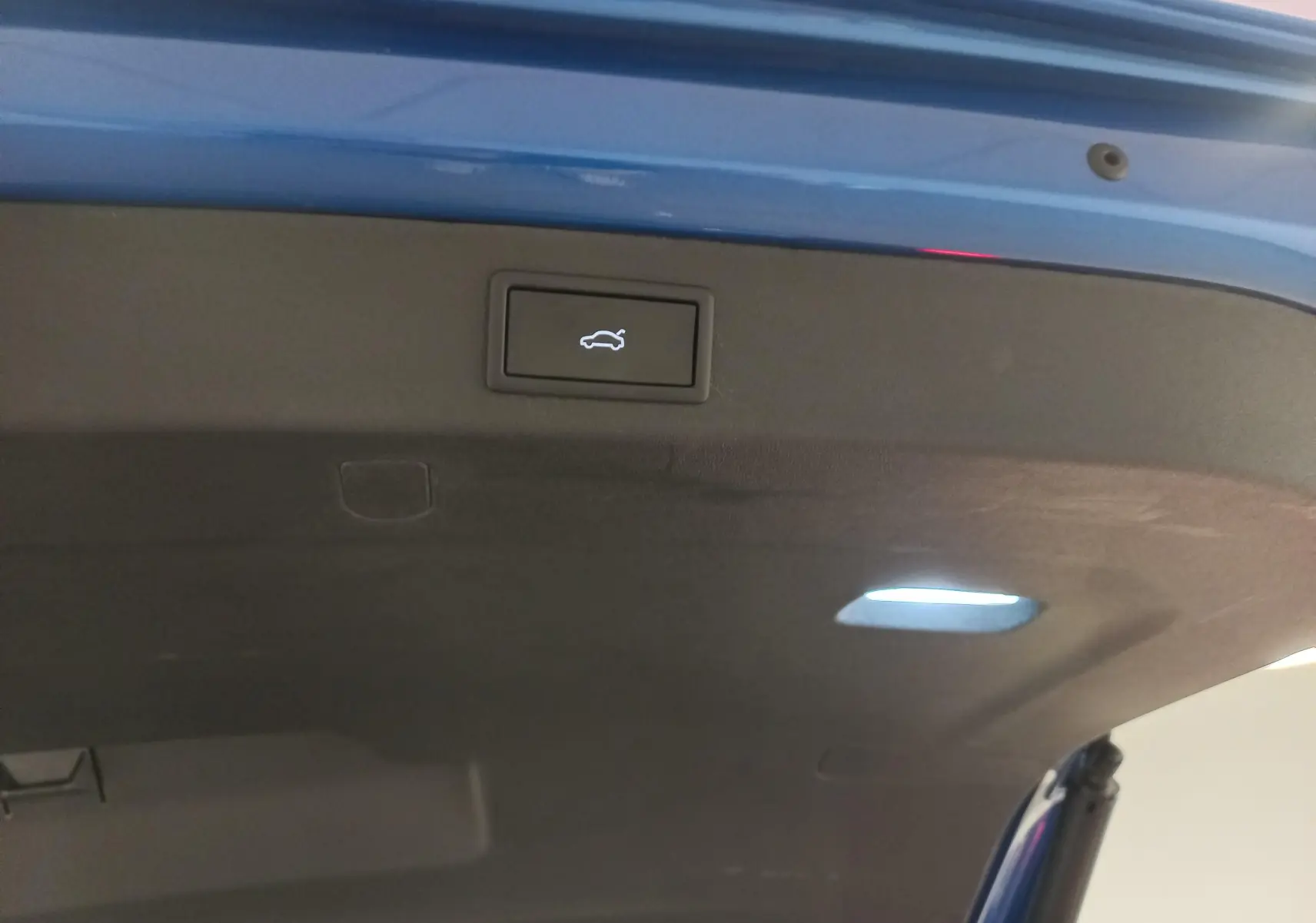 Bouton d'ouverture électrique du coffre sur la partie intérieure du hayon bleu RS du Skoda Kodiaq 2024.