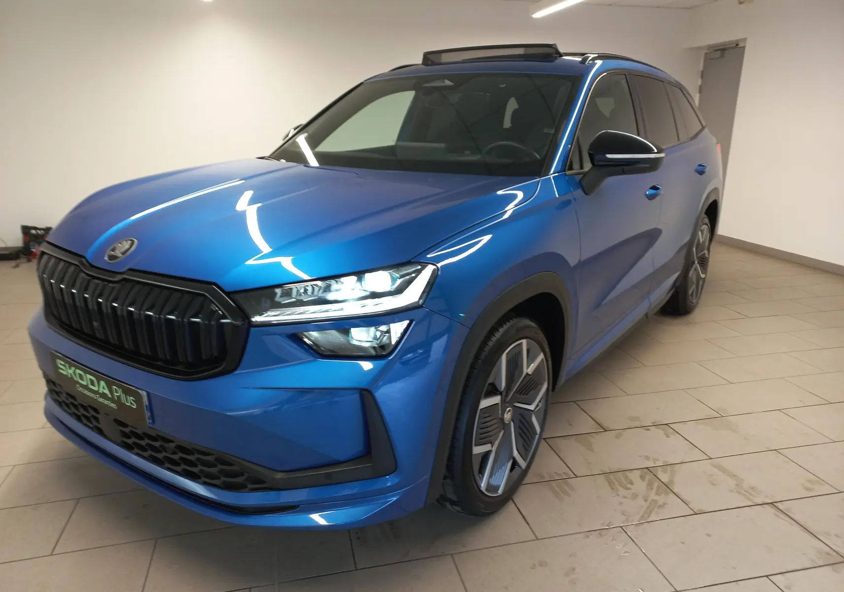 Vue 3/4 avant droite du Skoda Kodiaq 2024 Bleu RS avec calandre noire et jantes alliage 20 pouces anthracite.