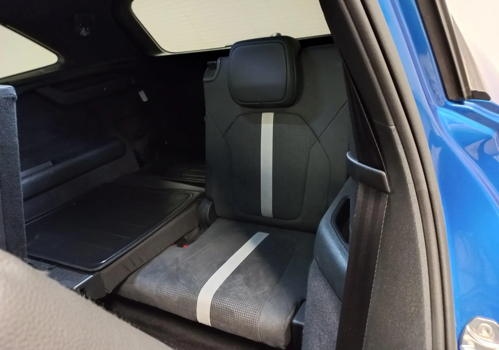 Vue intérieure sur le siège arrière droit du Skoda Kodiaq Bleu RS 2024, avec ouverture de porte et partie de la carrosserie visible.