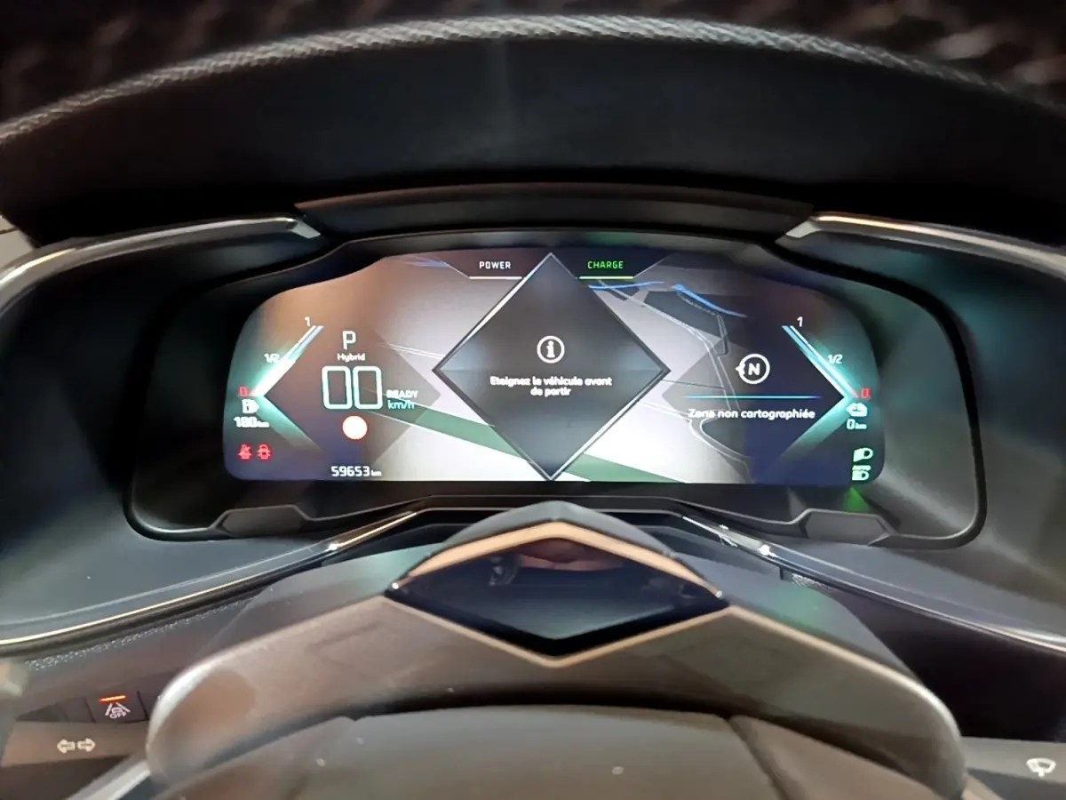 Vue rapprochée du tableau de bord numérique du DS7 Crossback E-TENSE 4x4 300 RIVOLI affichant les informations hybrides et la navigation.