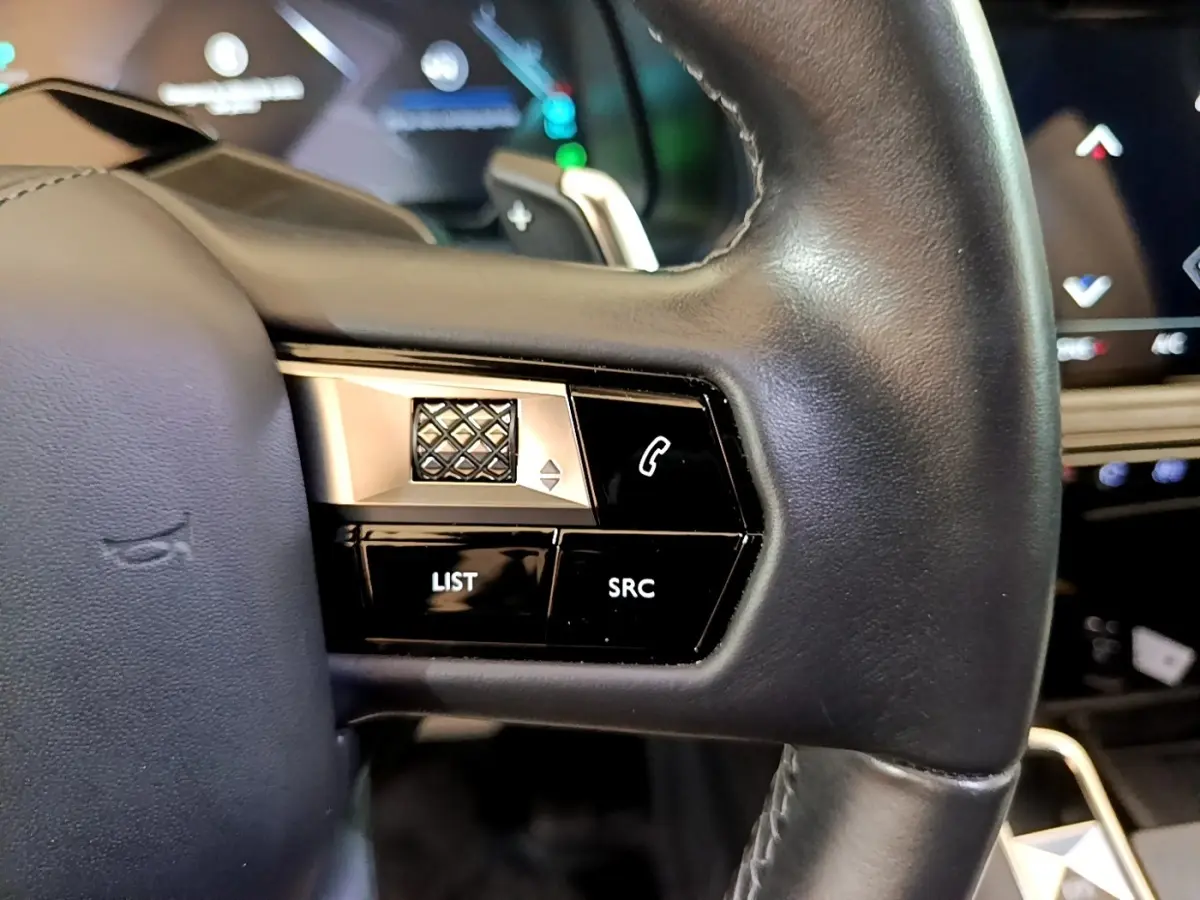 Gros plan sur les commandes gauche du volant cuir noir du DS7 Crossback E-TENSE 4x4 300 gris foncé, avec touches multifonctions.