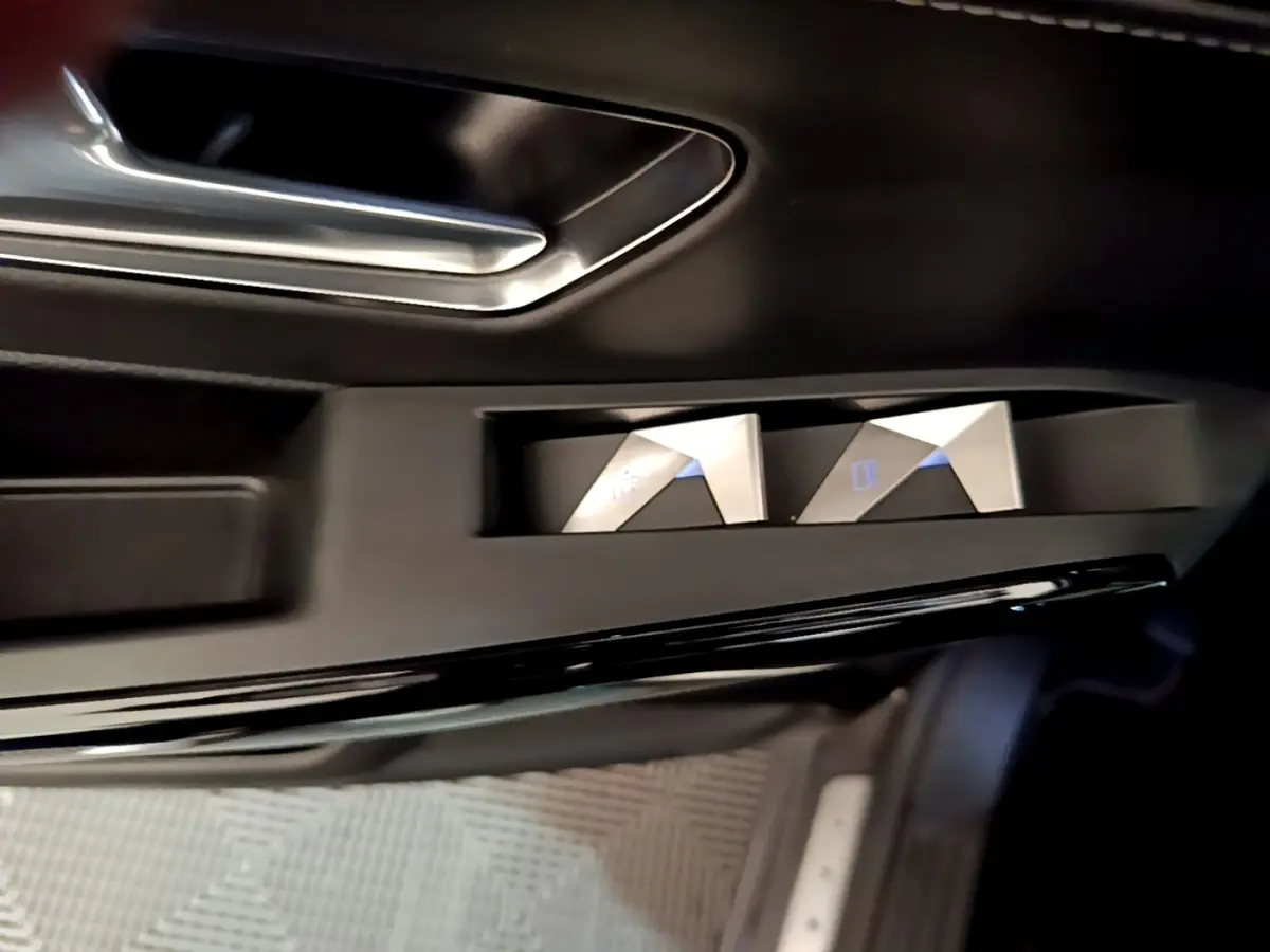 Détail des commandes de réglage des rétroviseurs sur la porte côté conducteur du DS7 Crossback gris foncé.