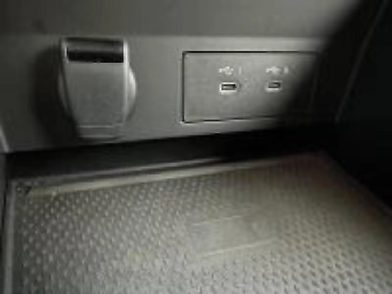 Prise USB double et prise 12V en gros plan dans l'habitacle noir du Renault Captur 2025.
