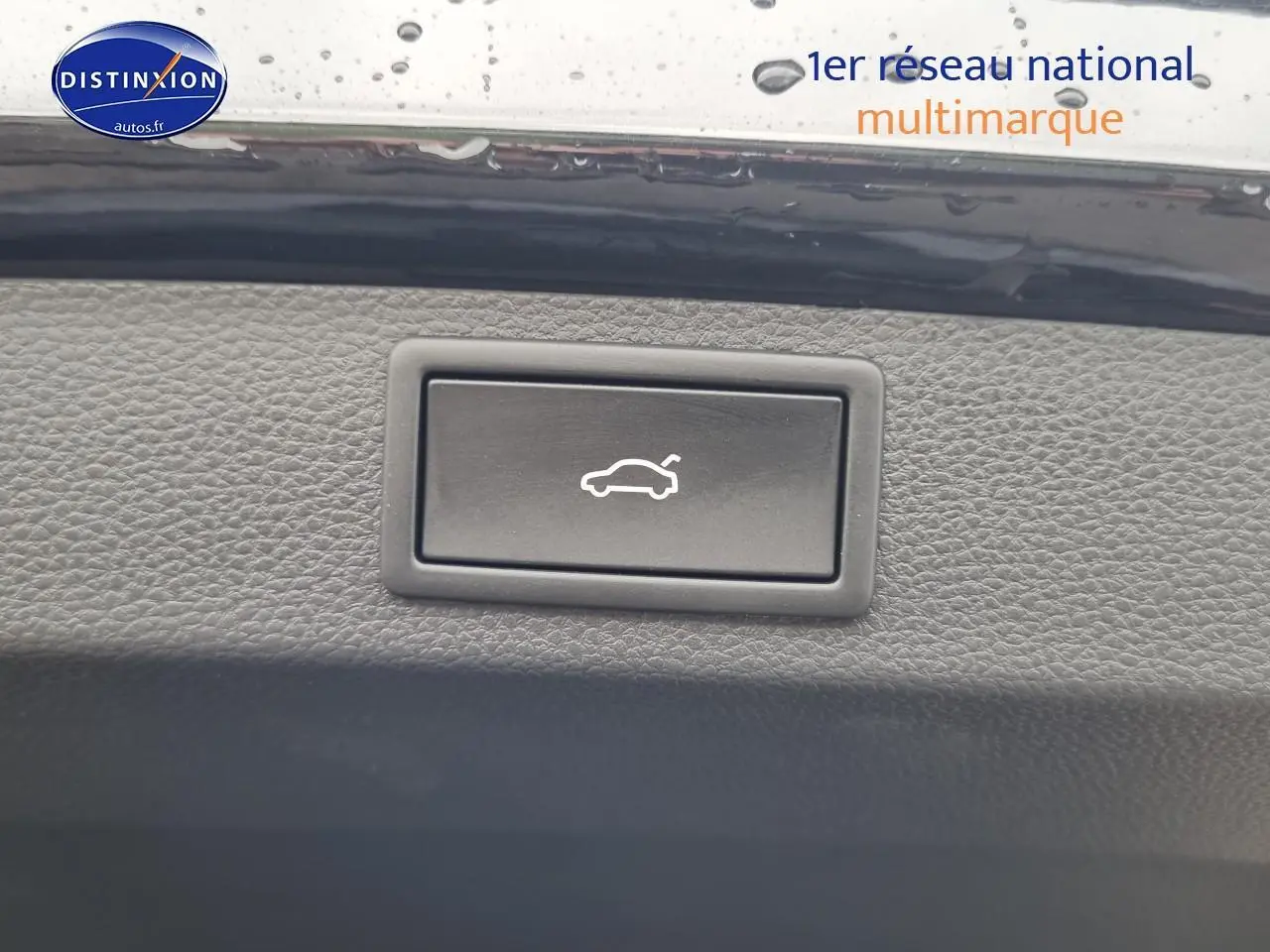 Bouton d'ouverture du coffre intégré dans le panneau intérieur noir d'un Skoda Karoq 2025.