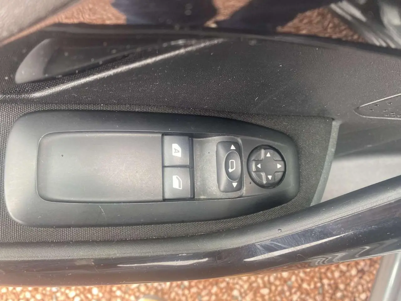 Commandes des lève-vitres et réglages des rétroviseurs côté conducteur de la Peugeot 208 gris shark 2013.