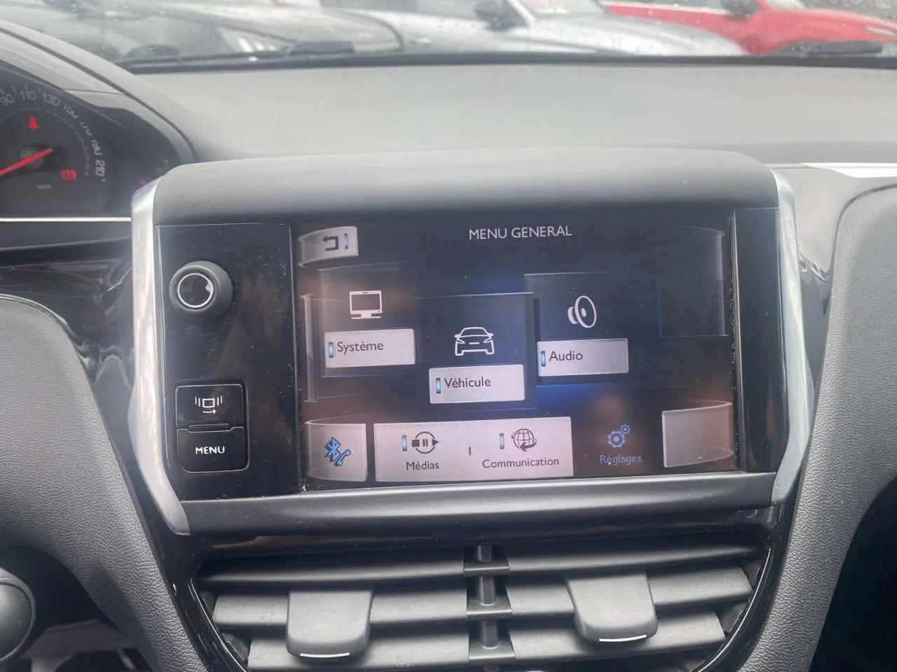 Écran tactile central du tableau de bord de la Peugeot 208 gris shark, affichant le menu général multimédia.