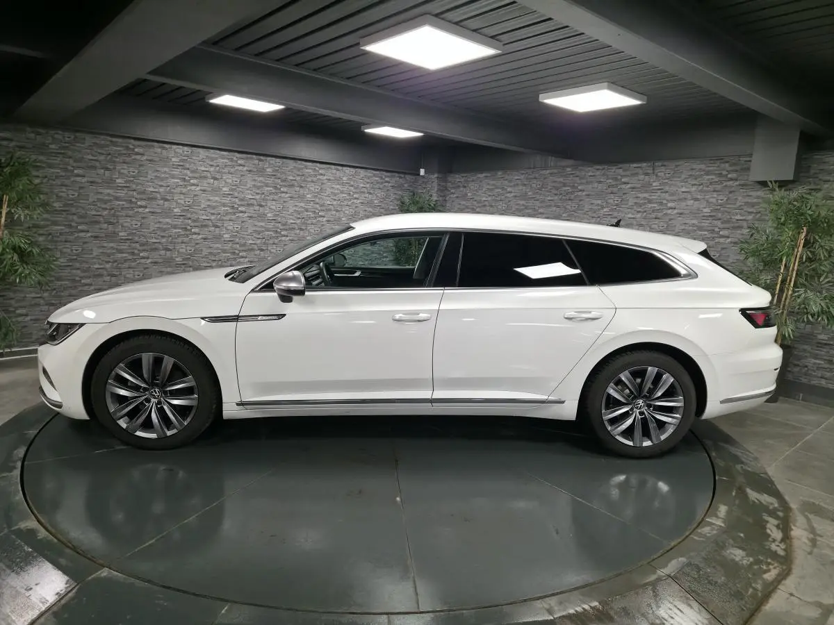 Volkswagen Arteon Shooting Brake blanc Oryx nacré, vue de profil côté gauche en intérieur avec jantes Almere 18 pouces.