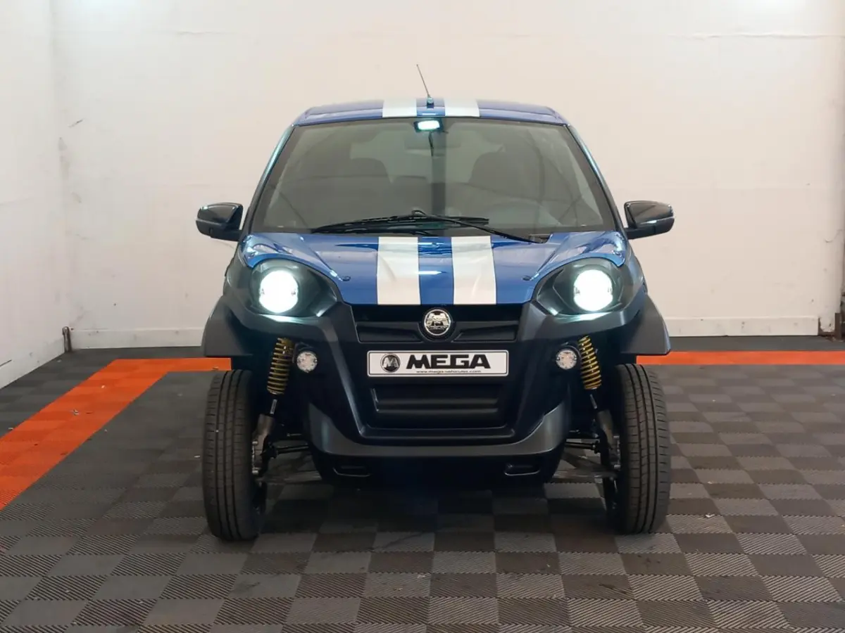 Vue avant d'une Aixam Mega E-Scouty Evo 2026 bleue avec bandes blanches, phares allumés et suspension visible.