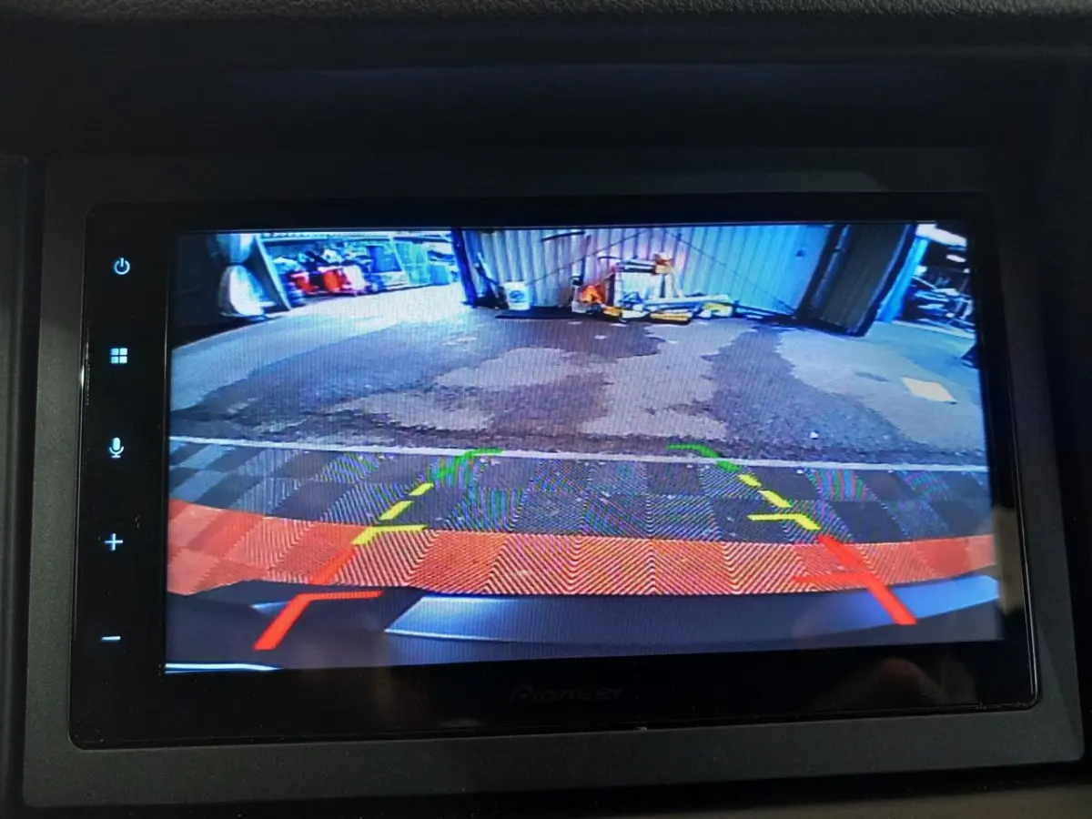 Vue de la caméra de recul côté conducteur de l'AIXAM MEGA E-SCOUTY EVO bleu, affichée sur l'écran intérieur.