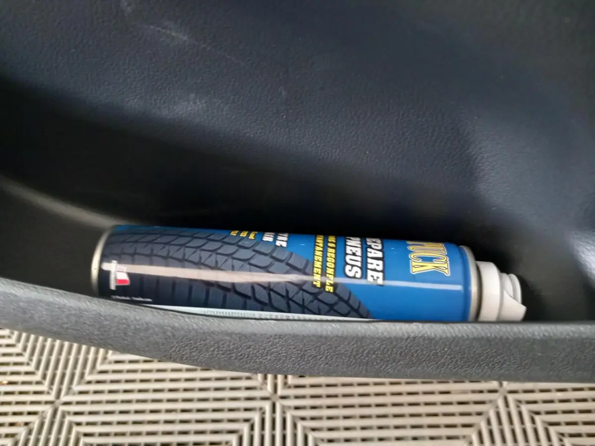 Gros plan sur une bombe de réparation de pneus bleue dans la porte intérieure d'une Aixam MEGA E-Scouty Evo 2026.